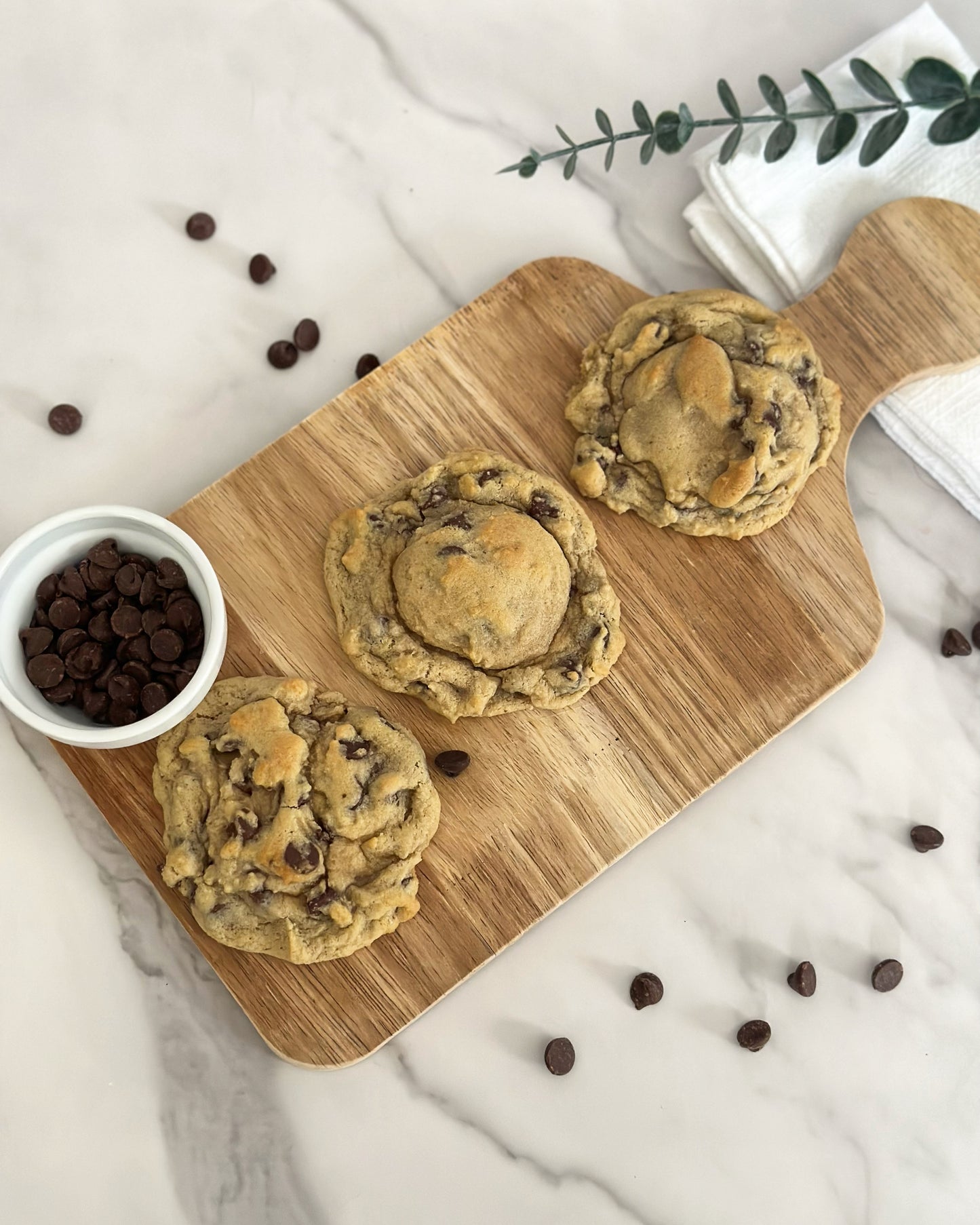 chocolate chip cookies on a board with chocolate chips